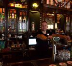 Barman Robert voor de kast, met het hergebruikte glas in lood van de bovenramen.
<br/>
Richard Keijzer, 2014-12-09